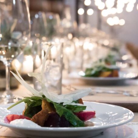 Elegant dinner setting with gourmet plated dishes and wine glasses.